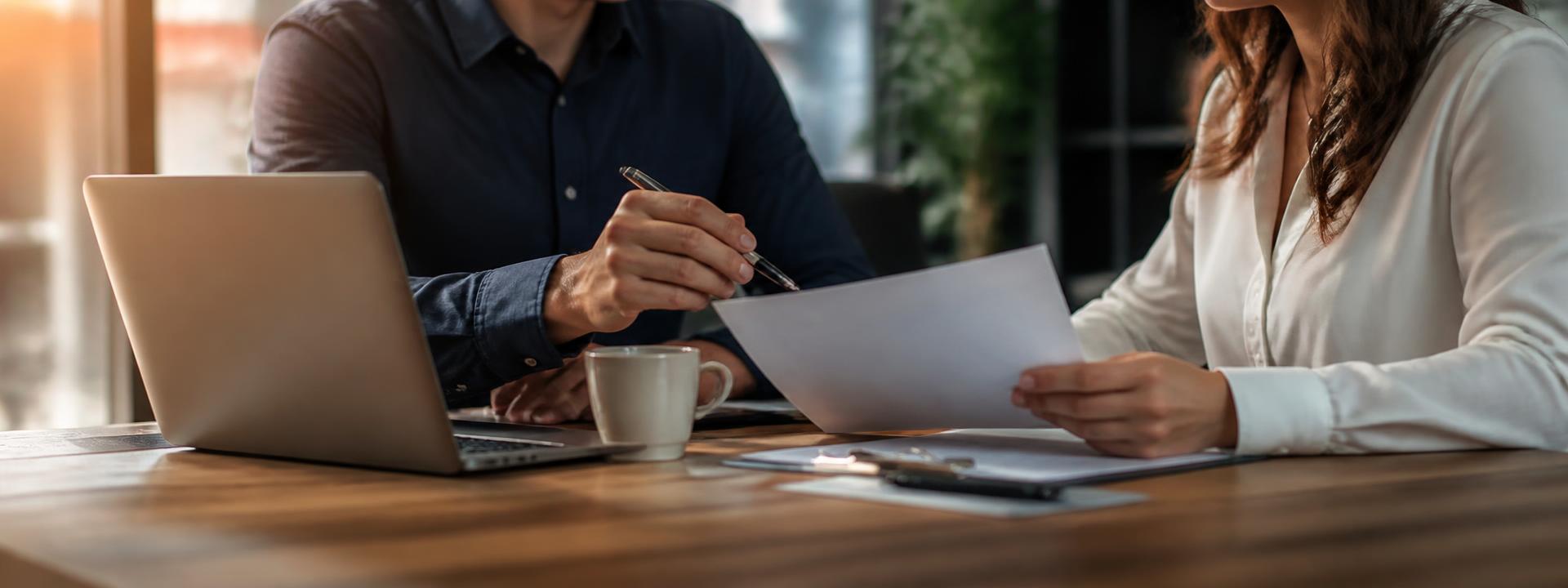 Two people reviewing documents together at a table